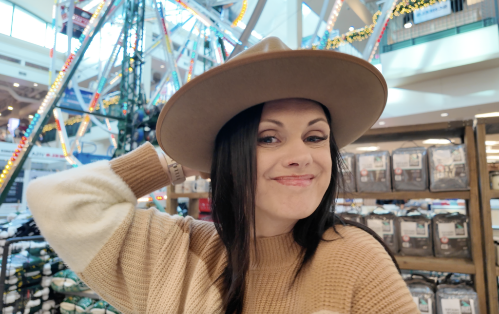woman smiling in a stylish hat at scheels