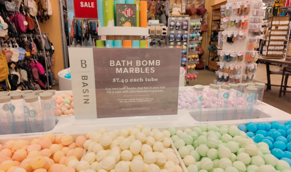 table full of mini bath bombs with a sign saying bath bomb marbles