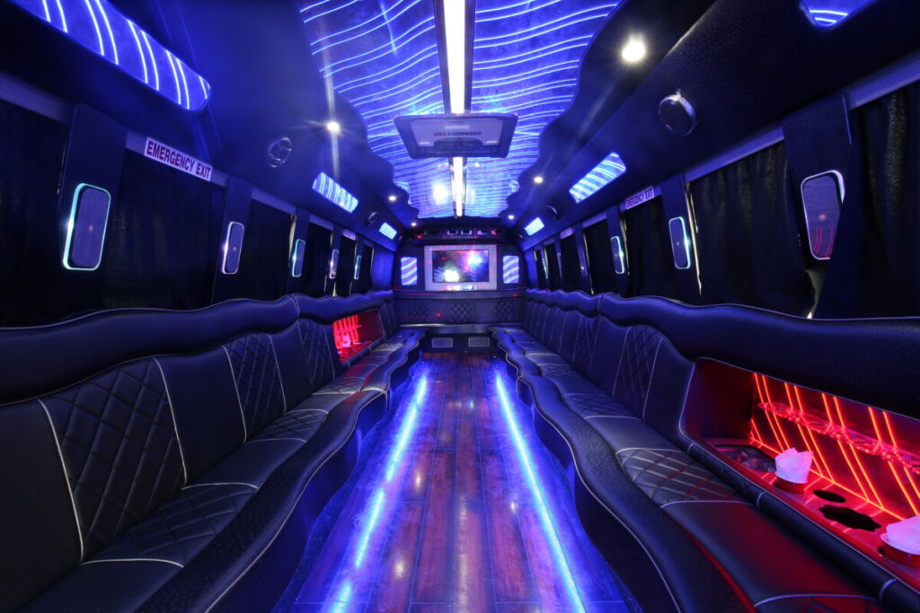 Inside of party bus with bright red and blue lights and benches to sit