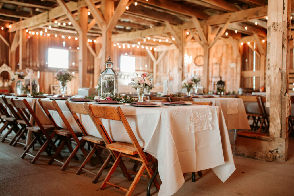 decorated table and chairs at a wedding venue inside a barn