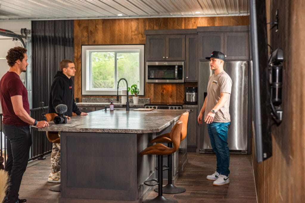 three men standing around kitchen island
