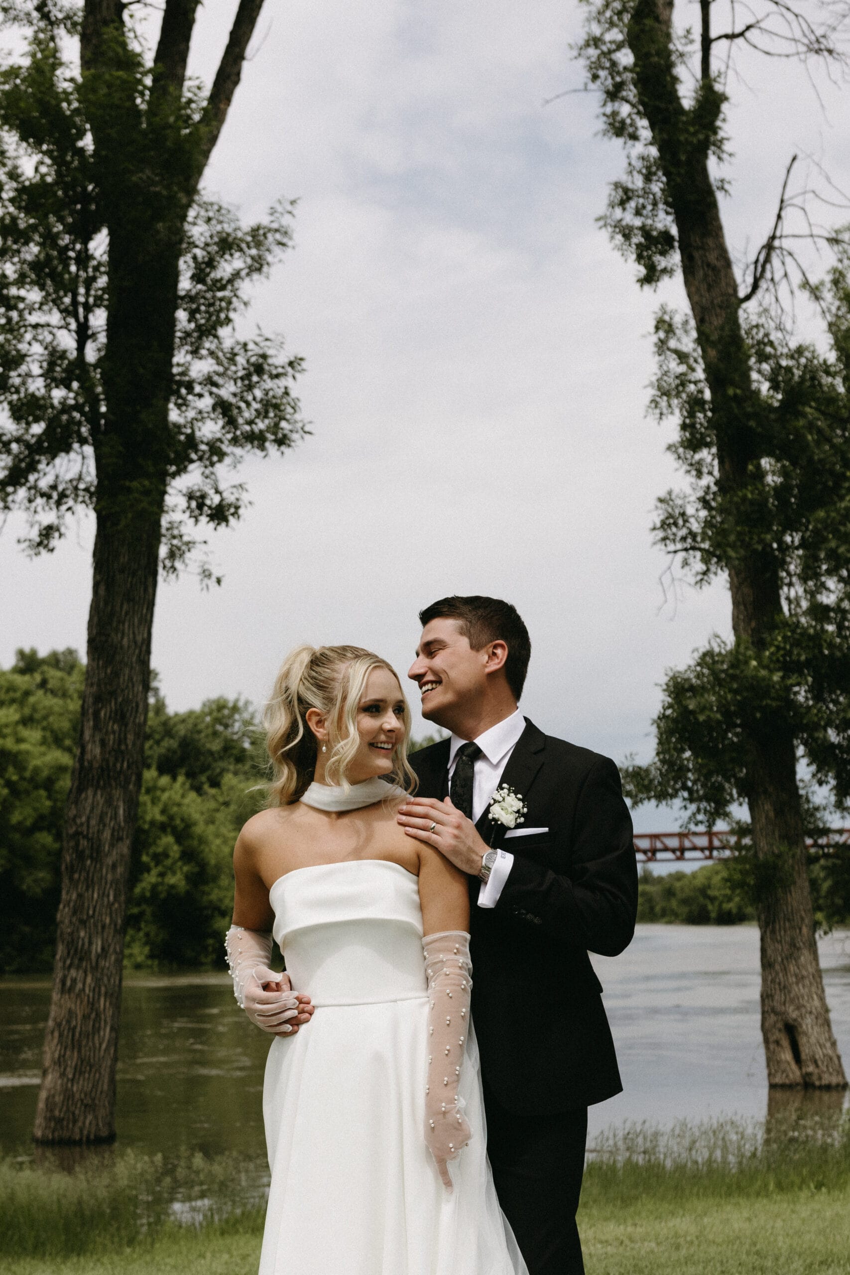 couple posing outdoors in wedding attire scaled