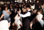 large group dancing and laughing at wedding