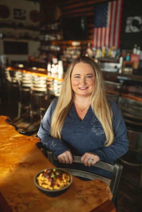 woman standing in bar with bowl of mac