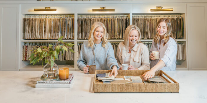 three women smiling looking at fabric samples.jpg